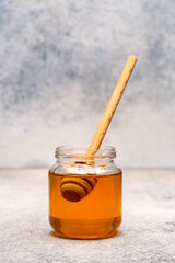 Honey jar and honey dipper on vintage background