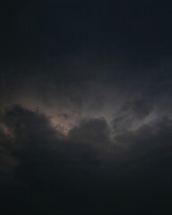 Obraz premium an ominous and dramatic sky filled with dark clouds, creating a sense of foreboding and tension. The clouds swirl and billow, hinting at the potential for a storm