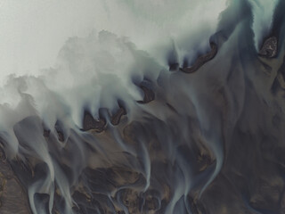 Aerial view of glacial river patterns creating ethereal, flowing designs across the landscape, South Coast, Iceland.