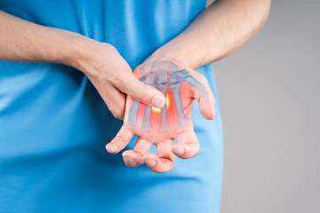 Hand pain, carpal tunnel syndrome, gray background, painful area highlighted in red