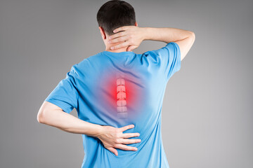 Intervertebral spine hernia, pain between the shoulder blades, man suffering from backache, spinal disc disease, gray background, health problems concept