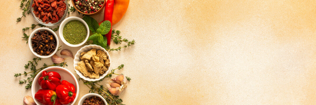 A warm display of spices and herbs on a beige background, each adding rich aromas and flavors, perfect for enhancing recipes, banner