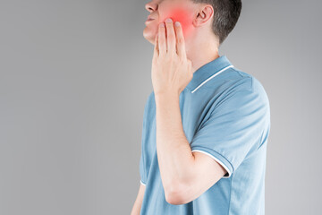 Man with toothache, periodontal disease in wisdom teeth, gray background