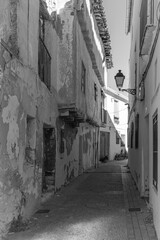 Obraz premium antigua calle medieval con paredes blancas con macetas de flores y pavimento de piedras en Requena, Valencia, Spain