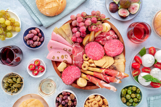 Italian Antipasti. Charcuterie platter with cheese and other snacks, with wine, overhead flat lay shot