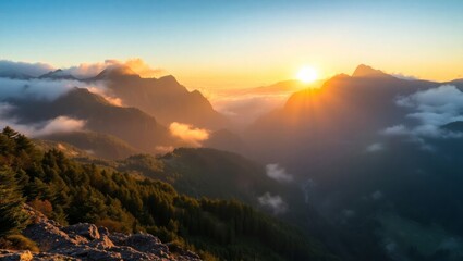 Dramatic mountain sunrise with fog rolling through valleys