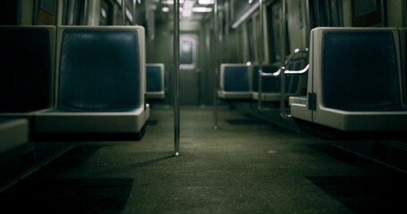 A quiet subway car reveals polished floors and empty seats as the fading daylight filters through the windows.