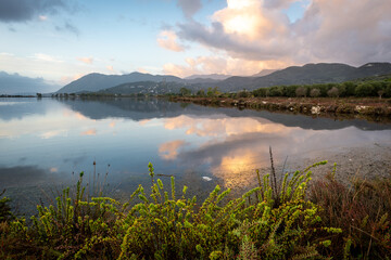 A wetland wildlife habitat, salt marshland, on an Autumnal morning with beautiful sky and cloud reflections on the till water.