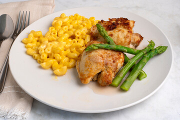 Fototapeta premium chicken thighs with macaroni and cheese and asparagus
