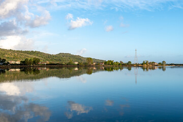 Land, sky and cloud reflections on the still waters of a wetland wildlife habitat.