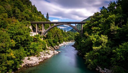 Scenic arch bridge over river in lush valley.