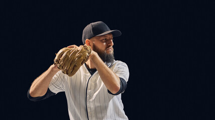 Baseball pitcher holding ball and glove in ready position on dark background. Concept of pitching preparation, focus, and technical training for coaching and sports visuals.