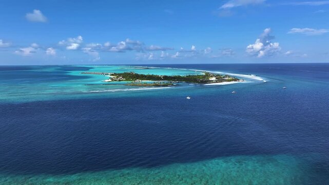 Aerial view of a resort Island's vibrant blue waters meeting white sandy beaches under a sunny sky, a Maldivian paradise, Thulusdhoo, North Male Atoll, Maldives.