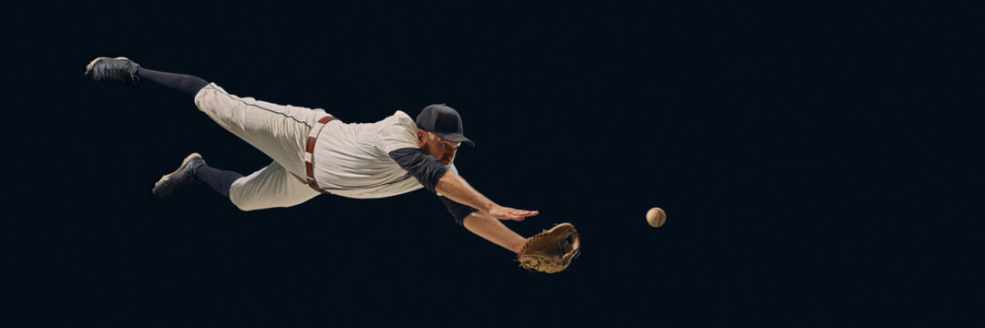 Baseball player diving full stretch catching ball midair. Concept of athletic dedication, fielding precision, professional sports visuals for training and editorial use. Banner - Powered by Adobe