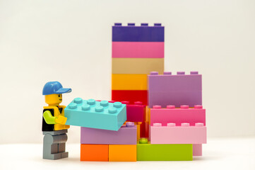 Naklejka premium LEGO miniature worker carrying a Lego brick. Educational children's toys. 