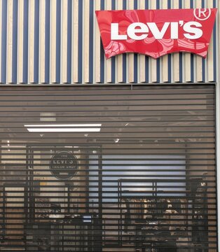 Fachada de tienda de moda Levis, con puerta cerrada por cortina plegable de metal, en centro comercial Islazul, Madrid, Espa&ntilde;a, 2 de noviembre de 2025	