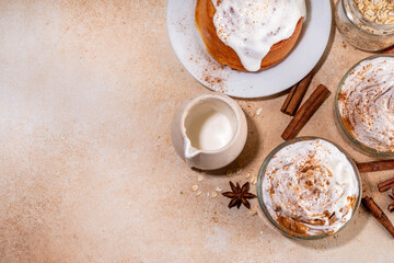 Delicious layered cinnamon roll overnight oatmeal. Tasty breakfast overnight oats in jar, tasty comfort morning food, sweet healthy snack with greek yogurt topping and sprinkle of cinnamon bun spice 