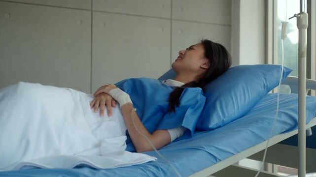 Woman patient sitting on hospital bed suffering stomach pain and diarrhea, feeling anxious about possible cancer and medical costs while waiting for diagnosis and treatment. Health insurance.
