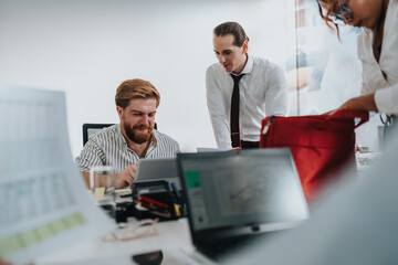 A group of colleagues works together at a bright desk, examining laptops and papers today.
