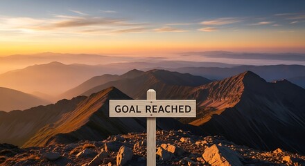 A wooden sign on a mountain peak reads goal reached, symbolizing achievement, success, and the culmination of hard work against a scenic mountain backdrop