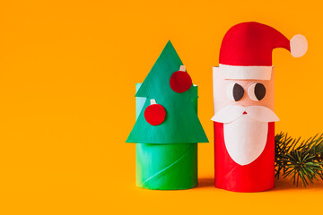 Christmas toy from toilet tube roll, paper toy santa claus, snowman, reindeer, tree rabbit on yellow background. Holiday easy kids DIY, decoration idea for winter season, home party. Children's crafts