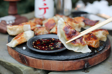Freshly pan fried dumplings served with flavorful dipping sauce, perfect for sharing