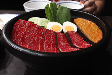 Delicious hotpot featuring thinly sliced beef, vegetables, and eggs, perfect for sharing