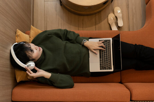 Girl multitasking, listening to podcast and working online.