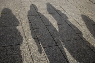 Shadows of People on City Pavement in Sunlight