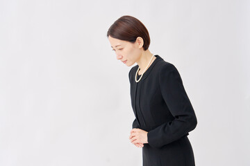 喪服を着た女性　お辞儀　白背景　左向き