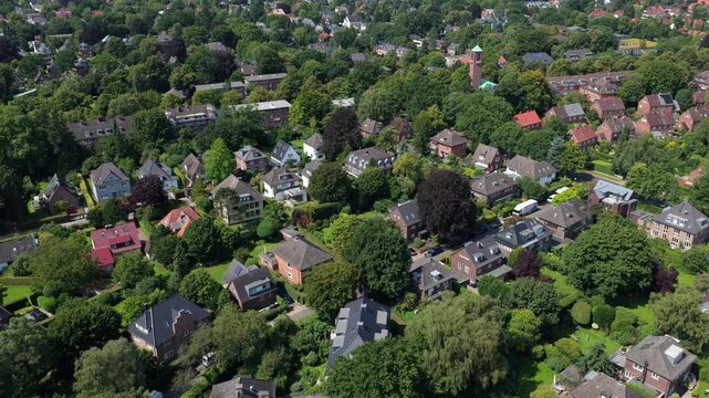 Aerial footage flying over a quiet residential district in Hamburg, Germany, with many trees and traditional houses in Europe