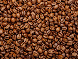 Roasted coffee beans covering the frame in rich brown tones under even studio light, top view texture background ideal for cafe branding visuals.