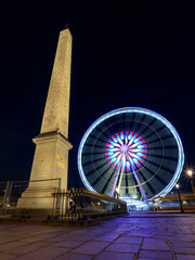 The Luxor Obelisk and the Ferris Wheel at night, located in the Place de la Concorde in the center of Paris.