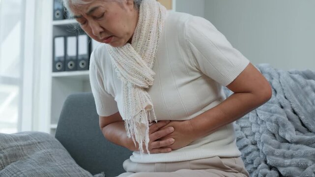Woman Experiencing Abdominal Pain Home Setting Health Issue Indoor Environment Close-up View Wellness Concern - Powered by Adobe