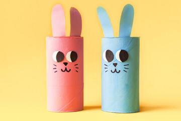 Christmas Easter toy from toilet tube roll, paper toy rabbit, tree on yellow background. Holiday easy kids DIY, decoration idea for winter season home party. Children's crafts