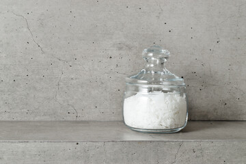 Magnesium Salt Flakes in glass Jar in grey bathroom, white natural sea salt, Magnesium therapy,...
