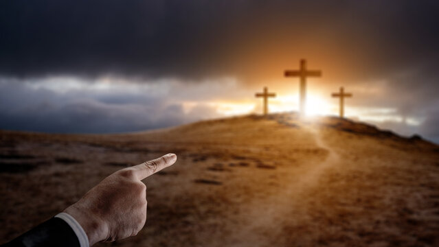 Business hand pointing path toward the Christian cross on the hill with dark dramatic sky background. Concept of Christianity, religious, faith, Jesus, or belief - Powered by Adobe