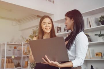 Two female friends are discussing work in the office.	