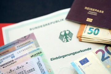 German passport and an identity card on an official naturalization certificate. Symbolic for successful acquisition of German citizenship close up