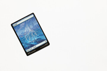 Naklejka premium Bradford, UK Nov 3 2025 Basic Land Island card from the Spider-man magic the gathering card game shot isolated on a white paper background.