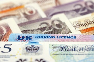 United Kingdom driving license card on UK British pounds money close up