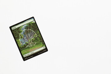 Naklejka premium Bradford, UK Nov 3 2025 Forest, basic land card from Spider-man magic the gathering card game shot isolated on a white paper background.