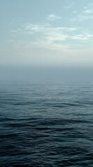 Obraz premium Serene ocean and tranquil cloudy sky meet at the calm horizon line.