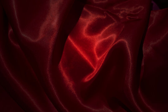 top view close-up of red satin fabric, smooth and luxurious, beautiful, classy, ​​wavy texture