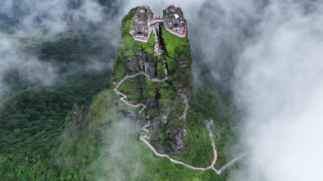 Aerial view of the Fanjingshan peaks piercing through the clouds, with winding pathways and temples perched atop, Fanjingshan, Guizhou, China.