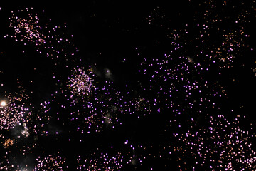  A stunning night sky with a dazzling animated fireworks display. Bright, multicolored fireworks on a dark background with glitter on a black background. Bursts of light in the sky. Add your text here
