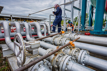 Male worker inspection at steel long pipes and pipe elbow in station oil factory during refinery valve of visual check record