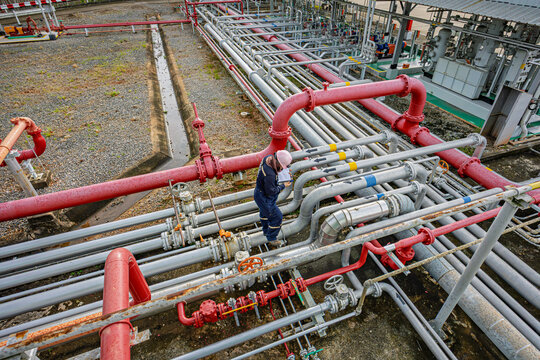 Top view male worker inspection at steel long pipes and pipe elbow in station oil factory during refinery valve of visual check record