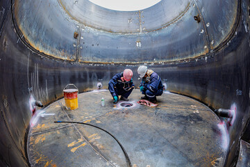 Top view male climbs up the stairs into the tank stainless chemical area inside
