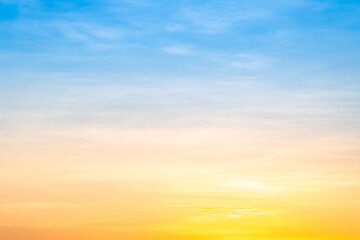 Sunset or sunrise sky with a vibrant gradient of orange, gold, and soft blue. Clear atmosphere with wispy clouds. Peaceful, natural light background. hope, freedom, new day and inspirational Concepts